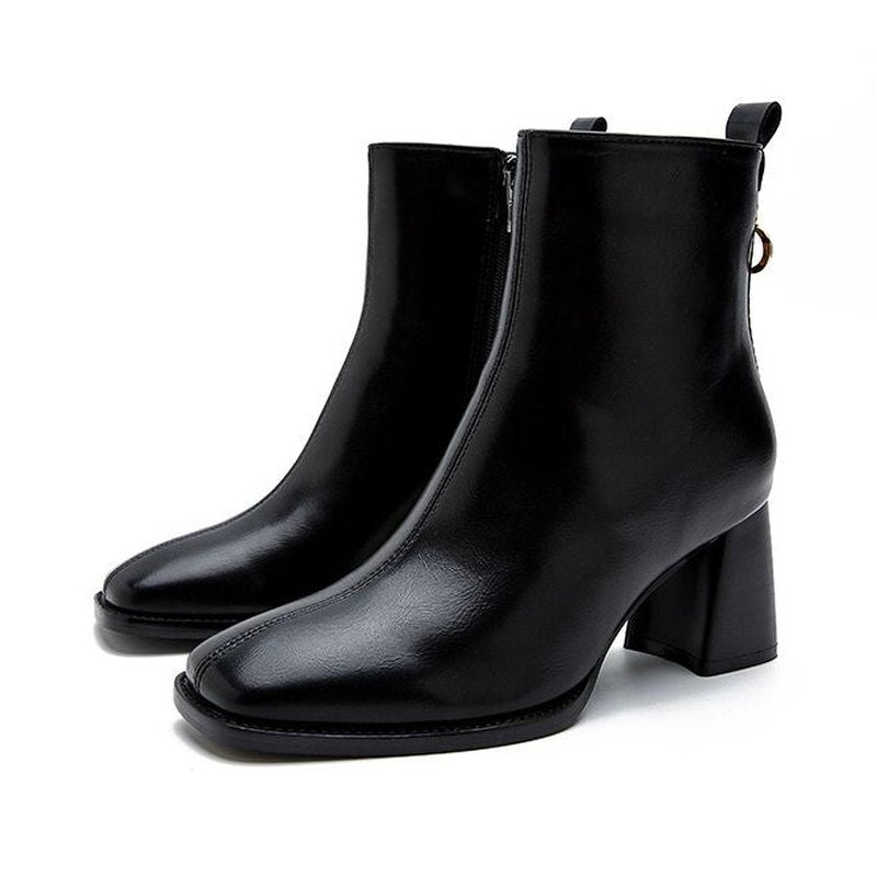 Pair of black leather boots standing together at a slight front angle.

