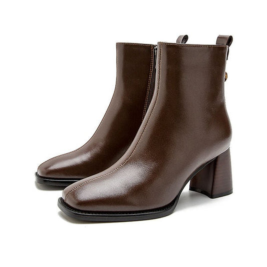 Pair of brown leather boots with wooden block heel displayed front angle on white surface.

