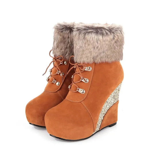 Front pair view of orange suede snow boots highlighting lace‑up front and platform height.