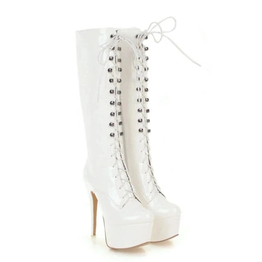 A pair of glossy white knee-high boots with lace-up fronts, round toes, and high stiletto heels, placed side by side against a white background.