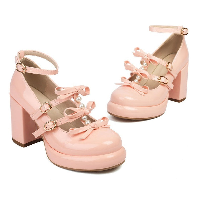 Pink Mary-Jane pair with chunky heels and front platform, three buckle straps with bows and pearl trim.