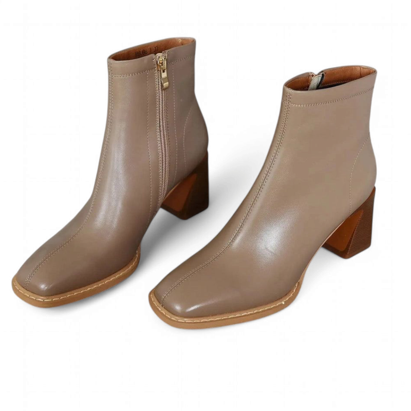 Pair of Ranya beige ankle boots with block heels on a white background