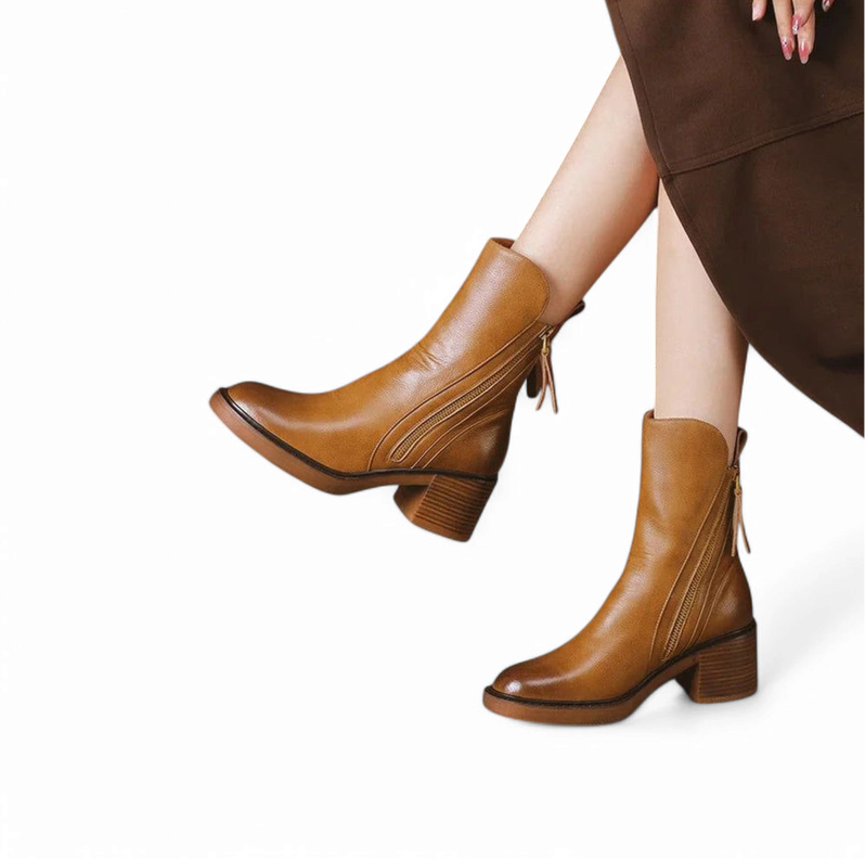 Pair of brown leather boots with block heel and visible side zipper

