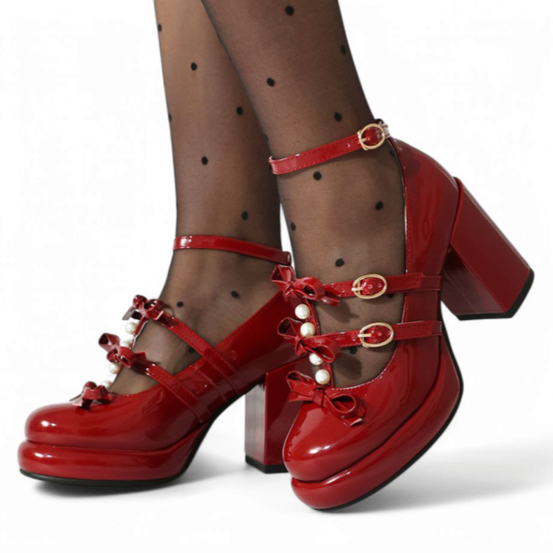 Glossy red Mary-Jane platform pump with chunky heel, three bow-topped straps and pearl accents, worn with dotted tights.