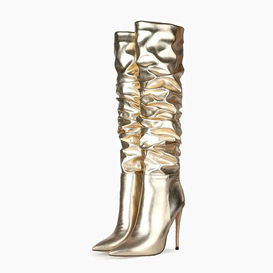 Partial front view of gold ruched boots with slender heels.