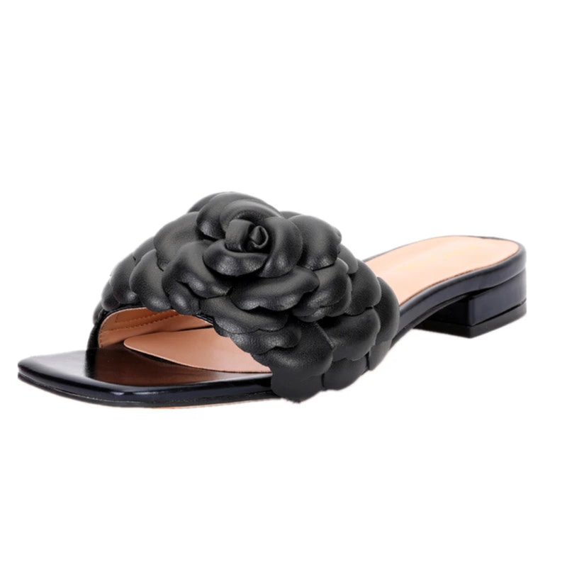 Black leather slide sandal shown from front side, highlighting floral strap and square open toe.