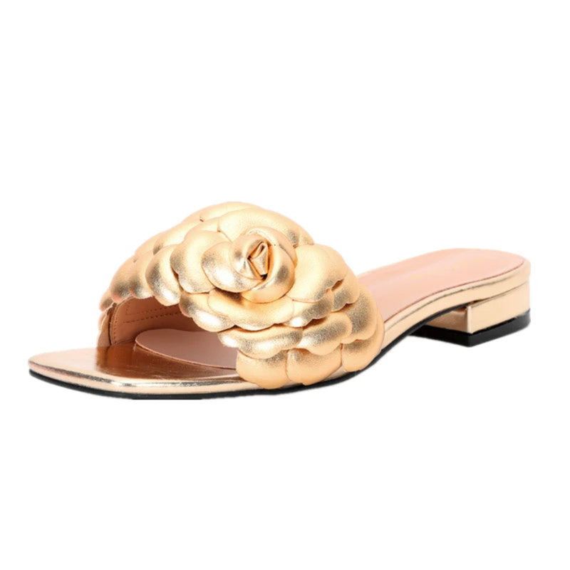 Front-angle view of gold leather slide sandal with sculpted rose and low block heel.