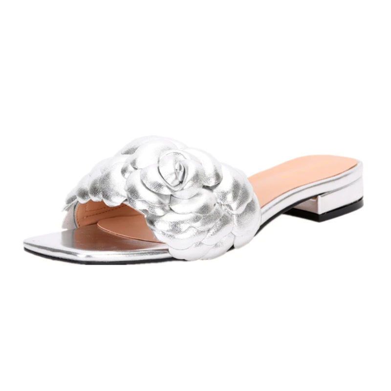 Three-quarter view of silver leather slide featuring padded rose detail and 2 cm heel.