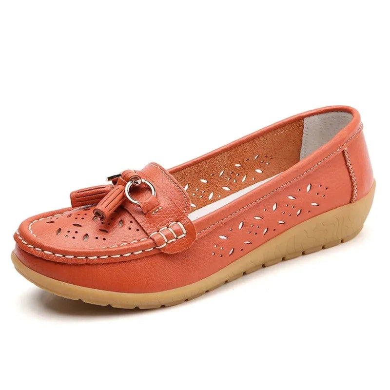 Salmon‑orange perforated loafer, tassel ornament visible