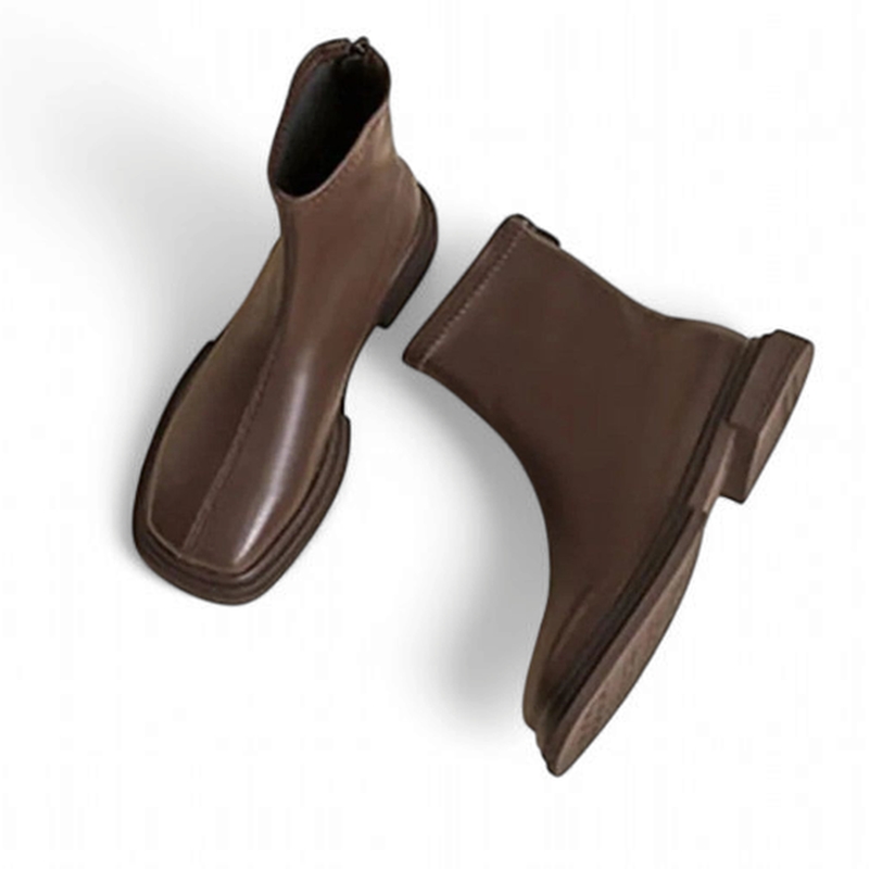 A pair of brown leather boots with square toes and back zippers, shown in a side angle highlighting the upper and sole.