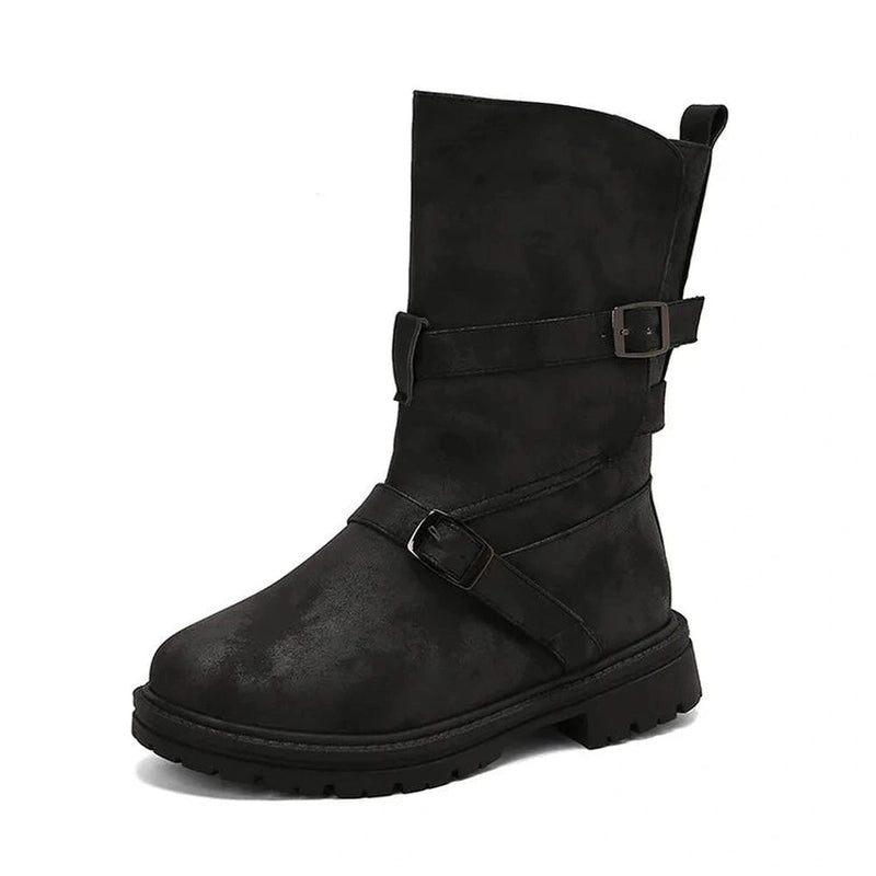 Side profile showcasing the overlapping leather straps and low square heel black boot