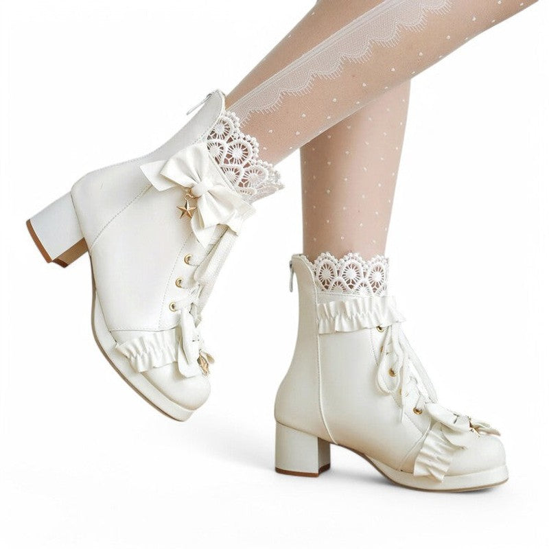 A woman wearing a white Victorian ankle boot, shown from the side. The photo highlights the satin bows, lace-up front, block heel, and soft lace trim, with the boot styled as part of an elegant outfit.