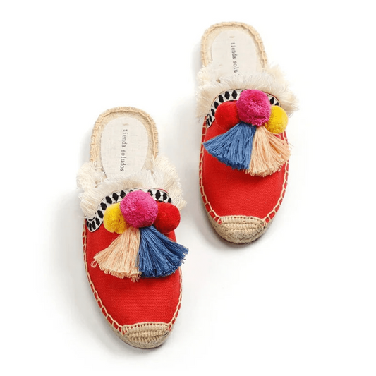 Red espadrille mules with colorful tassels, angled pair