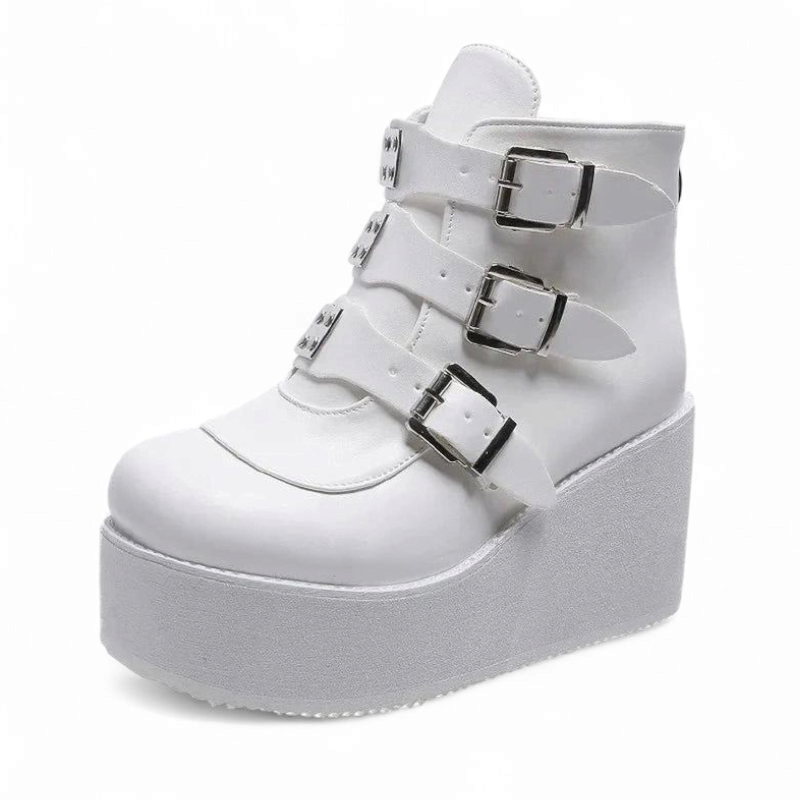 Side view of solid white wedge boot with metal buckles.