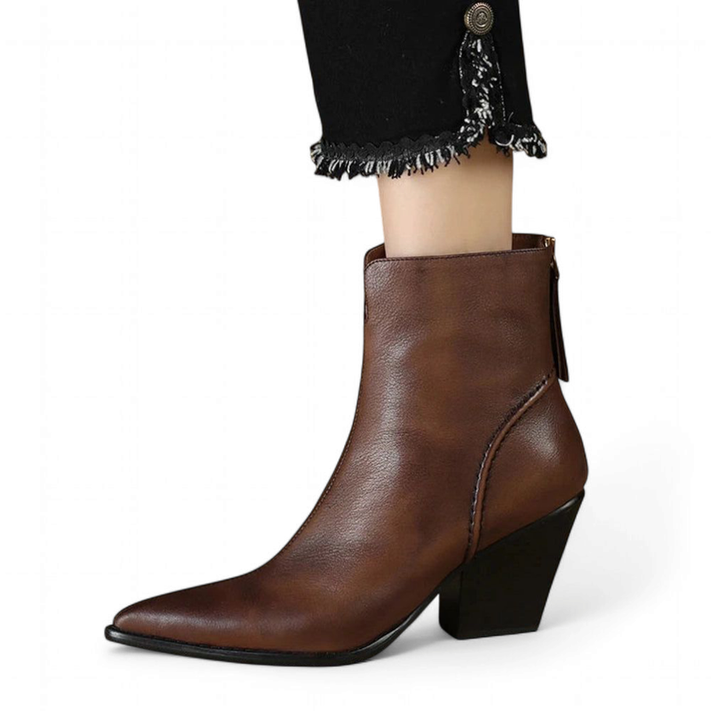 Brown leather ankle boot with pointed toe and block heel, shown from the side while worn.

