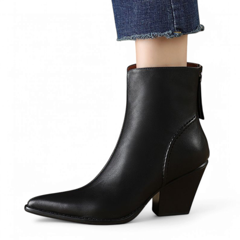 Single black leather boot with pointed toe and high heel, shown from the side while worn.

