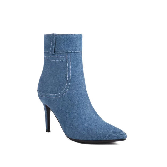 Single blue denim bootie, side view highlighting white top-stitching and pointed silhouette.