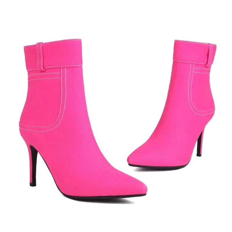 Two hot-pink ankle boots with slim stiletto heels and pointed toes, facing opposite directions.