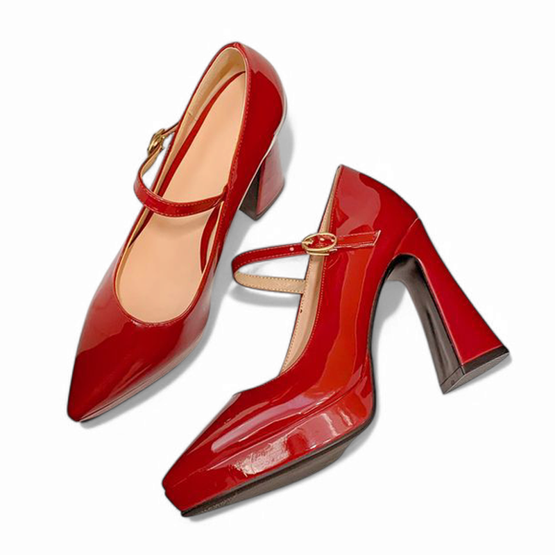 Red Mary-Jane pumps laid flat on white background, pair view.

