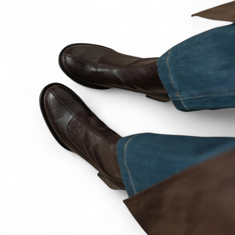 Detailed close-up of brown mid-calf boots with neat stitching and stable sole