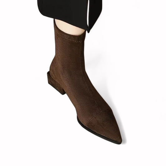 brown women’s ankle boots made of soft faux suede, featuring a pointed toe, low square heel, and above-ankle height with rear zip closure.