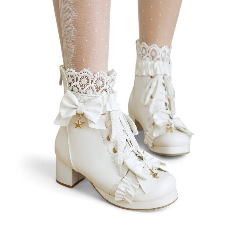 A white Victorian-style ankle boot worn by a woman, showing the lace-up front, satin bows, and lace trim peeking from the top, styled with feminine attire.