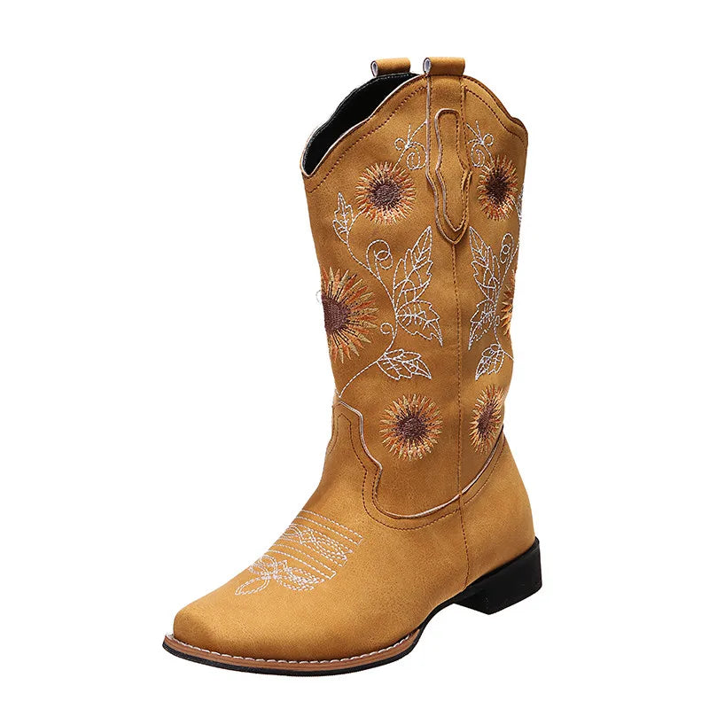 Single yellow cowboy boot with sunflower embroidery and white stitching, isolated on white.