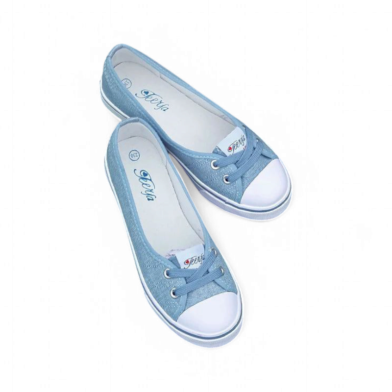 Light-blue canvas flat showing white cap toe and rubber foxing stripe.
