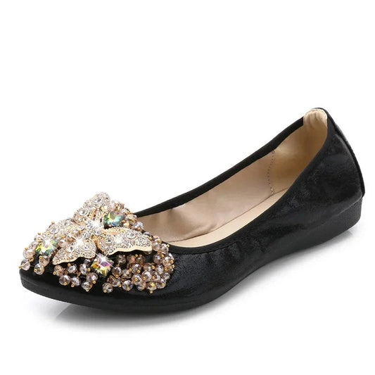 Black glossy-leather ballet flat with a pointed, crystal-butterfly toe ornament.