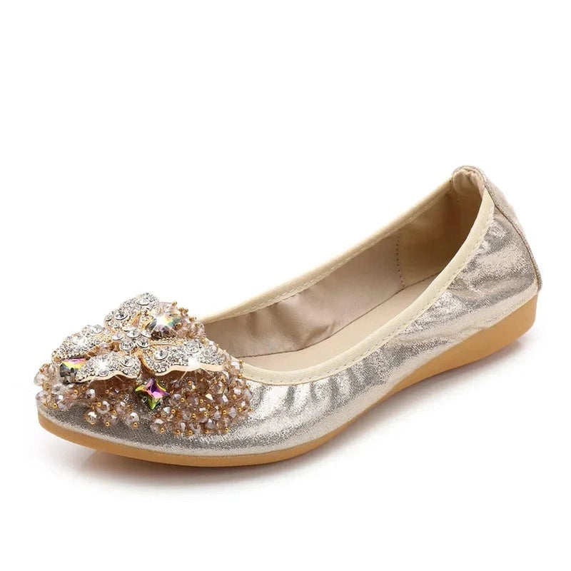 Gold metallic-leather ballet flat with a pointed, crystal-butterfly toe ornament.
