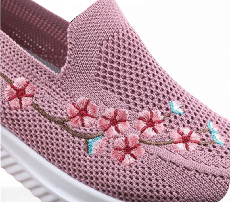 Side view highlighting cherry‑blossom embroidery on the breathable knit upper.
