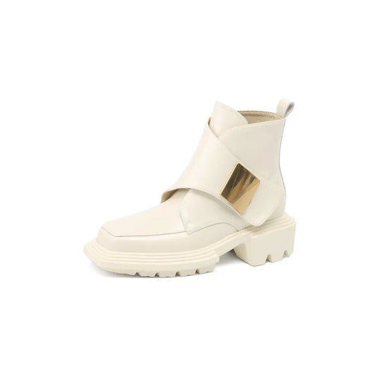 Beige split leather women’s ankle boot with wide metallic front strap on white background