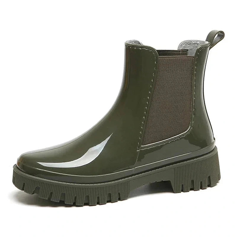 Glossy olive green Chelsea boot with round toe and chunky heel – side view.