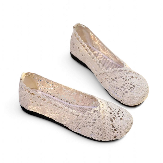 Angled side view of beige Merendy Sika flats showing lace overlaps, round toe, and black sole.